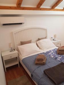 科米扎Little Green House的一间卧室配有一张带蓝白色毯子的床