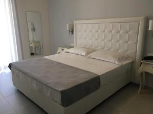 维耶斯泰Hotel Puglia Garden的卧室配有一张大白色的床和大床头板