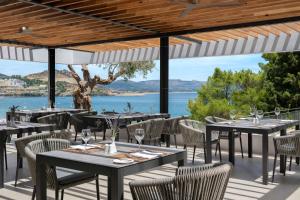 林都斯Lindos Mare, Seaside Hotel的一间带桌椅并享有水景的餐厅