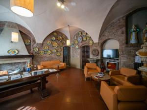 圣吉米纳诺美丽生活酒店的客厅配有橙色椅子和石墙