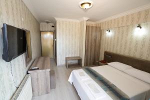 库萨达斯卡格达斯酒店的配有一张床和一台平面电视的酒店客房