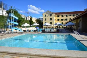 卡尚布Hotel Glória Resort & Convention的一个带桌子和遮阳伞的大型蓝色游泳池