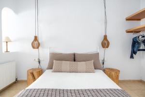 奥诺斯奥诺斯蓝色公寓的一间卧室配有一张白色床和两张木凳