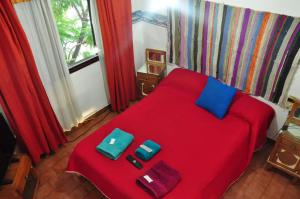 维拉卡洛斯帕兹Hotel La Marina的一间卧室配有红色的床,上面装有两袋