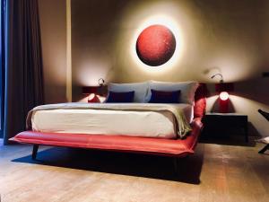 曼杜里亚Masseria Li Reni的一间卧室配有一张大床和红色长凳