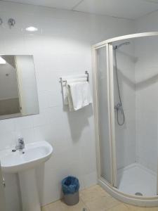 滨海罗克塔斯佩德罗胡安膳食公寓酒店的带淋浴和盥洗盆的白色浴室