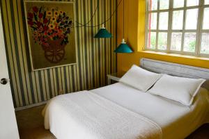 派帕德尔温托别墅度假屋的卧室配有白色的床和墙上的绘画作品