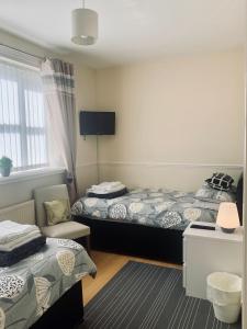 利物浦Be My Guest Liverpool - Ground Floor Apartment with Parking的酒店客房,配有两张床和椅子