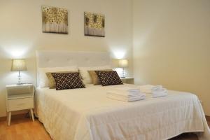 格兰杜拉Casa da Villa-Grândola的卧室配有白色床和毛巾