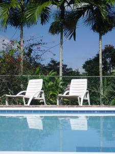 Oracabessa罗望子大府酒店的两把白色椅子坐在游泳池旁