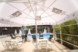 北马马亚-讷沃达里Hotel Dedal的一个带桌椅的白色遮阳伞下庭院