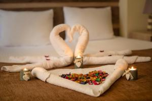 哥里MK旅馆的一张带两条毛巾天鹅和几根蜡烛的床