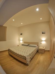 罗萨诺CASA VACANZE MARIAELENA - SANT' ANGELO的一间卧室配有床和圆镜子
