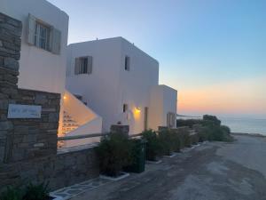 纳乌萨Sea & Sun Paros的一座白色的建筑,背靠大海