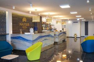 贾迪尼-纳克索斯Nautilus Hotel的餐厅设有黄色和蓝色椅子的柜台