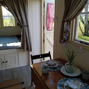 ÉchauffourThe English shepherds hut @ Les Aulnaies的一张木桌,上面有花瓶