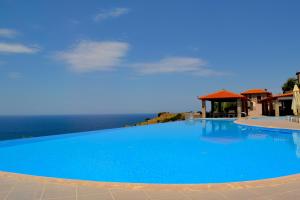 米西姆纳Villa Molivos Castle的一个蓝色的大型游泳池,背景是大海