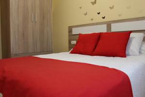 利洛Casa do Roxo de Rinlo Nº REGISTRO VUT-LU-00706的卧室内的红色床和红色枕头