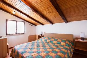 波雷奇Apartment Armando的一间带一张床的卧室,位于带木制天花板的房间内