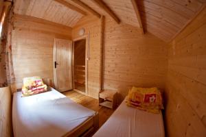 米泽德沃兹加比OW山林小屋的小木屋内带两张床的小房间