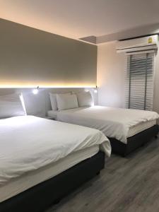 曼谷城市别墅的酒店客房设有两张床和窗户。