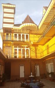 PanjakentInn Sogdiana的一座黄色的大建筑,设有门廊和阳台
