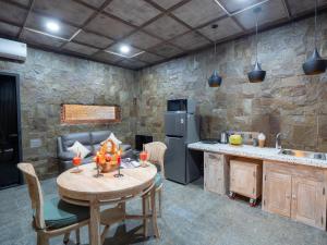 特贾库拉奥克托帕斯别墅的厨房配有木桌和石墙