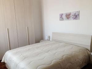 比耶拉A casa di Antonella的白色卧室配有一张床,墙上挂着一幅画
