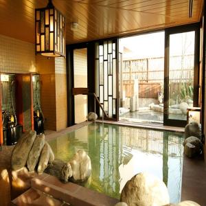 鹿儿岛多美迎鹿儿岛酒店的一座大型游泳池,位于一座带大窗户的建筑内