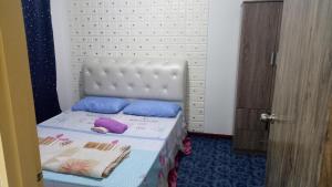哥打京那巴鲁Elaine @ Home Stay的小卧室配有白色床和紫色和蓝色枕头