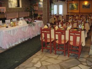 萨莫科夫克斯特尼特家庭酒店的用餐室配有带白色桌布和椅子的桌子