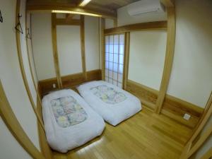 成田成田机场桑多旅馆的铺有木地板的小客房内的两张床