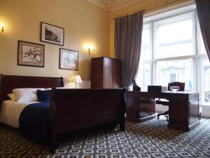 爱丁堡提斯特尔酒店的一间卧室配有一张床、一张书桌和一个窗户。