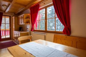 霍茨科波霍尔耶Bolfenk lodge apartment的厨房配有木桌和红色窗帘