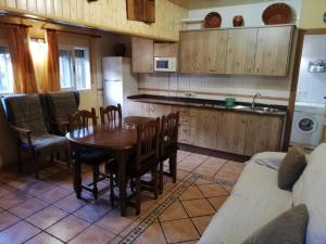 阿罗约弗里奥Alojamientos Rurales Vado Ancho La Encina的一间带木桌和椅子的厨房以及一间带厨房的厨房。