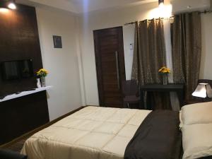 DaetMIRASOL Residences的酒店客房,配有床和电视