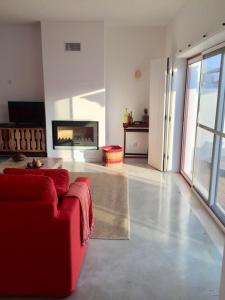 孔波尔塔Casa Oliveiras的客厅配有红色沙发和电视