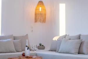 米科利维亚Naxian Pearl的白色沙发,配有一瓶葡萄酒和玻璃杯
