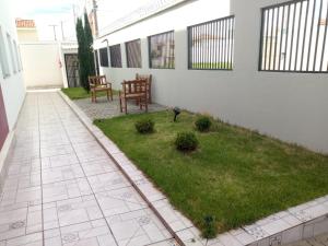 马里利亚Hotel HOSPEDA Marília的庭院设有草坪和两把椅子