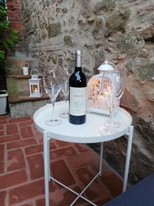 蒙特卡蒂尼泰尔梅Casa Dalia的一张带一瓶葡萄酒和两杯酒的白色桌子