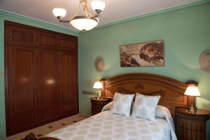 阿尔玛格鲁CULTURAS Y COLORES EN ALMAGRO -WIFI alta velocidad, NETFLIX y Parking-的一间卧室配有一张床、两盏灯和吊灯。