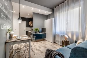 博洛尼亚Ugo Bassi Apartments的一间带蓝色沙发的客厅和一间厨房