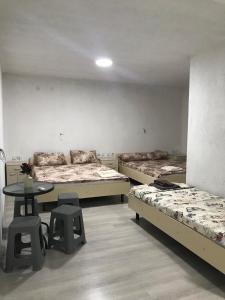 斯塔多伊兰Apartments Groshev的带三张床和桌椅的房间