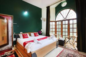 迈索尔LikeMyHome Homestay Mysore的一间卧室设有一张大床和绿色的墙壁