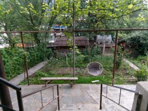 博尔若米Guest House Borjomi的一个带长凳和鸟笼的花园