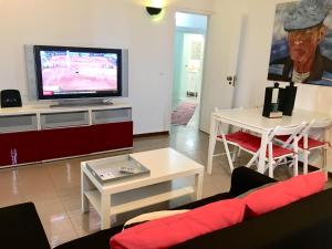 卡帕里卡海岸Brisa de Mar apartamento Costa da Caparica的客厅配有电视、沙发和桌子