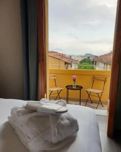 佛罗伦萨G&G FIRENZE SUITES的窗前床上的白色毛巾