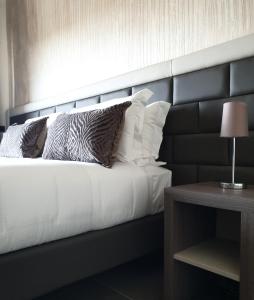 佛罗伦萨G&G FIRENZE SUITES的一间卧室配有一张带黑色床头板和枕头的床。