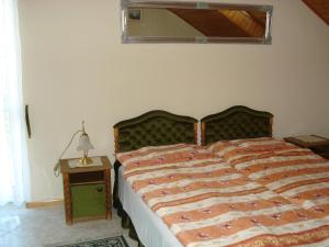 巴拉顿菲赖德皇家别墅酒店的一间卧室配有一张床和一张带台灯的桌子