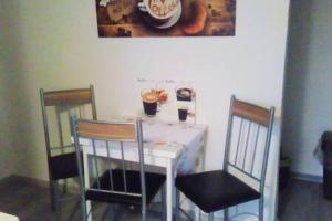 爱尔福特Kleines Apartement zwischen Ega und Messe Erfurt的餐桌、两把椅子和一张白色的桌子